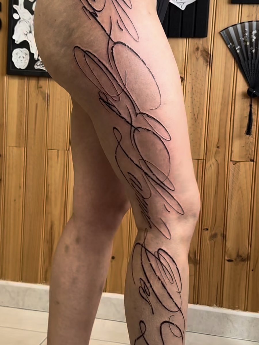 Lettrage calligraphique sur toute la jambe